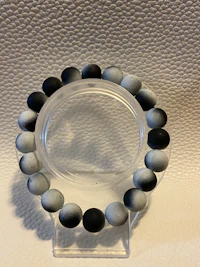 a black and white bead bracelet on a white surface