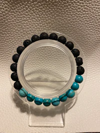 a bracelet with black and turquoise beads