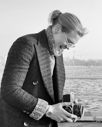 a man holding a camera on a dock