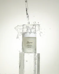 a bottle of water is being poured over a block of ice