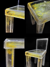 a chair made of clear plastic with yellow paint on it