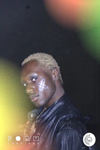 a man with blond hair in front of a blurry background
