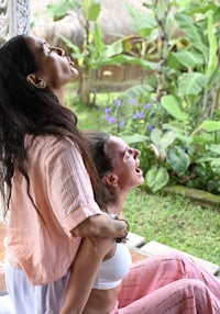 a woman is being massaged by another woman in a garden