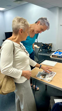 two women looking at a book at a table