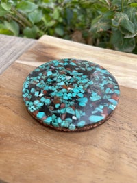 a turquoise stone coaster on top of a wooden cutting board