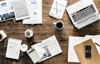 a desk with a laptop, phone, and other office items