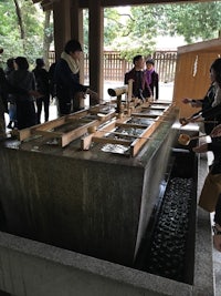 a group of people standing in front of a water fountain
