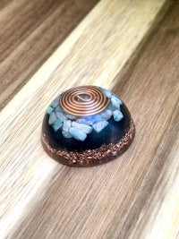 a blue and copper bead on a wooden table