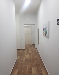 a hallway with white walls and a painting on the wall