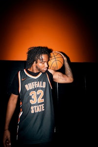 a man with dreadlocks holding a basketball