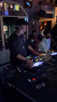 a group of people watching a dj at a night club