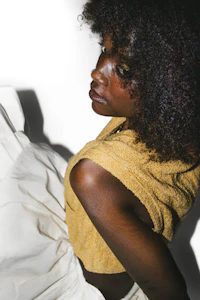 a black woman in a yellow top and white skirt