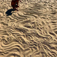 a man is drawing in the sand on a beach
