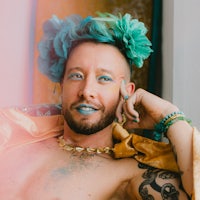 a man with blue hair sitting on a couch