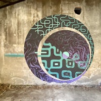 a mural painted on a wall with a purple and blue design