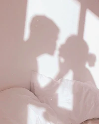 a shadow of a couple kissing on a bed