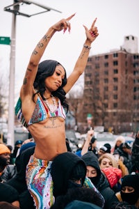 a woman in a colorful outfit riding on top of a crowd of people