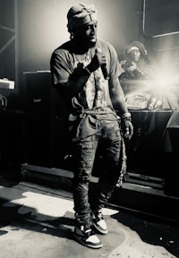 a black and white photo of a man standing in front of a microphone