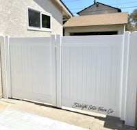 a white gate in a yard with a sign on it