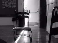 a black and white photo of a chair in a kitchen