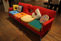 a red couch with a lot of pillows on it