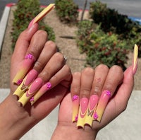 a pair of hands with pink and yellow nails