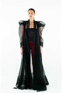 a woman wearing a black sheer robe and red pants