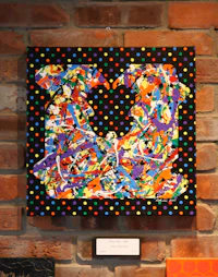 a colorful painting hanging on a brick wall