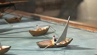 miniature boats on display in a glass case