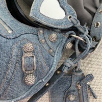 a blue denim purse with a chain on it