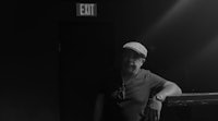 a black and white photo of a man standing in a dark room