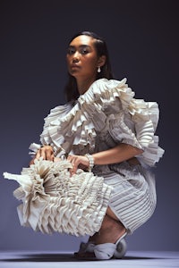 a woman in a white ruffled dress crouching down