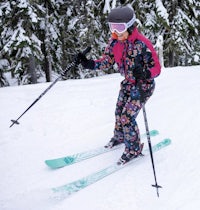 a woman is skiing down a snowy slope