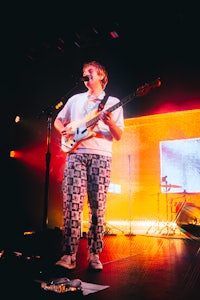 a man on stage with a guitar and microphone