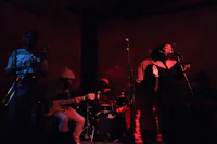 a group of people playing music in a dark room