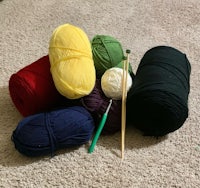 a pile of yarn and knitting needles on the floor