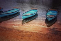 three boats on the shore of a body of water