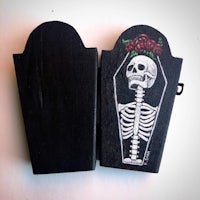 a wooden coffin with a skeleton and roses on it