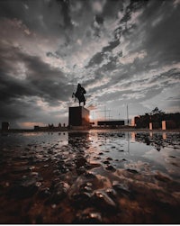 a statue of a man standing in a puddle of water