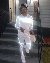 a man in a white tracksuit walking down the stairs