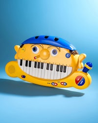 a yellow toy piano with a face on it