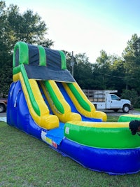 a blue and green inflatable water slide in a grassy area