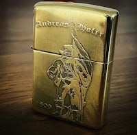 a gold lighter with an image of a man holding a flag