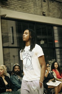 a man with dreadlocks walking down the runway