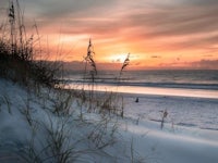 sand dunes on the beach at sunset