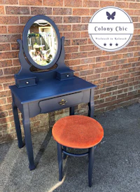 a blue dressing table with a mirror and stool