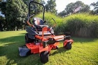 a black and orange lawn mower on a grassy lawn