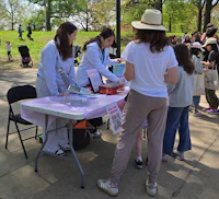 a group of people standing around a table in a park