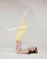 a woman doing a handstand in yellow pants