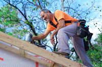 a man working on the roof of a house
